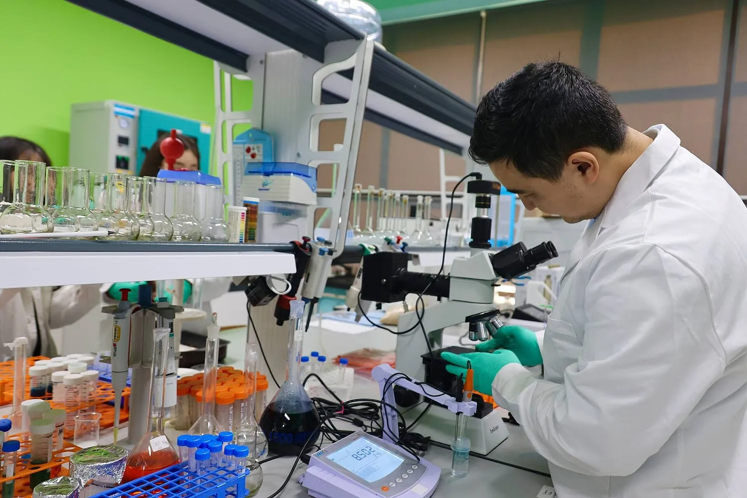 A technician working with water containers in a treatment laboratory